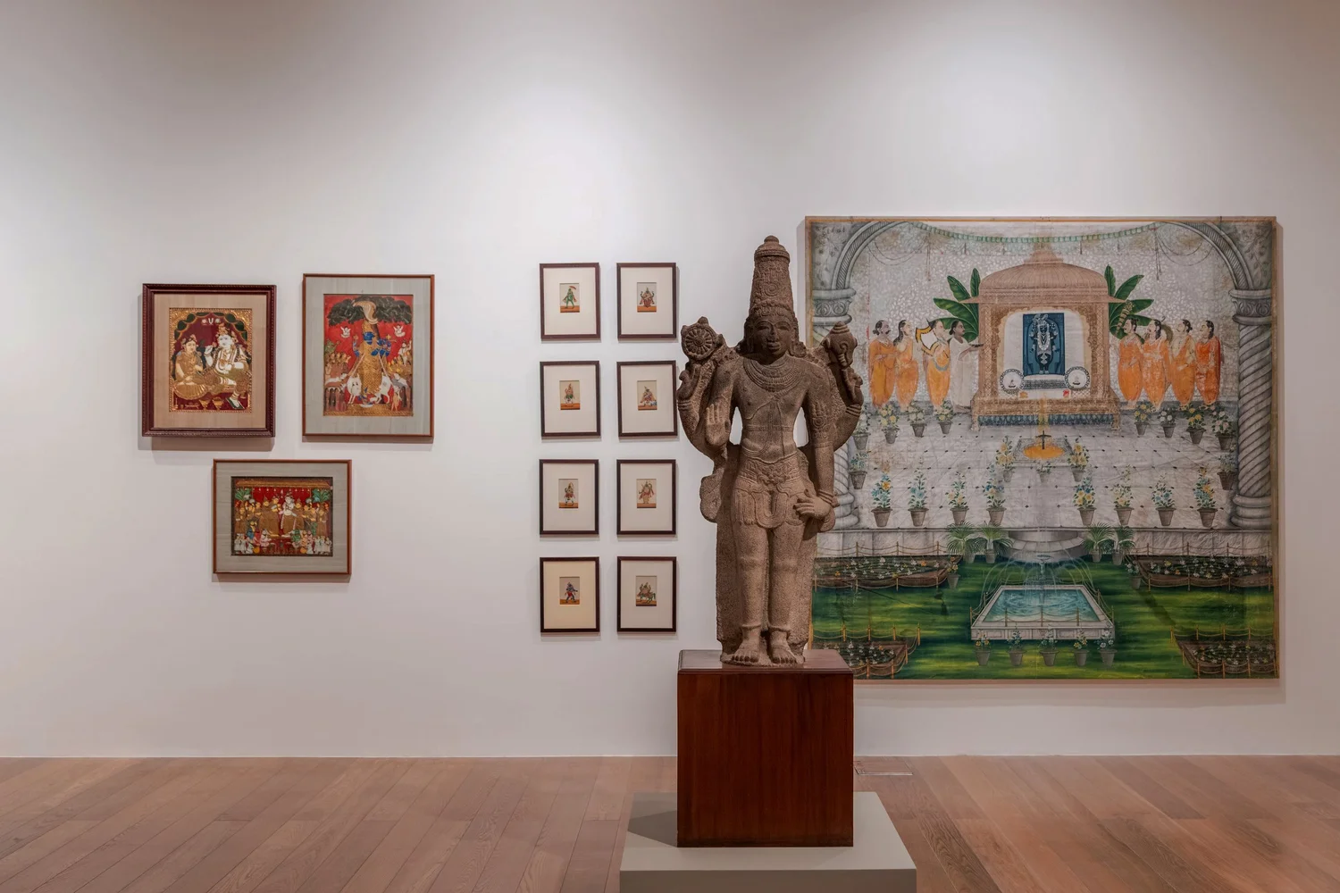 Gallery wall of devotional paintings and a sculpture