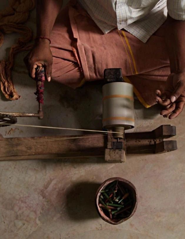 Artisan using a handloom to weave cloth