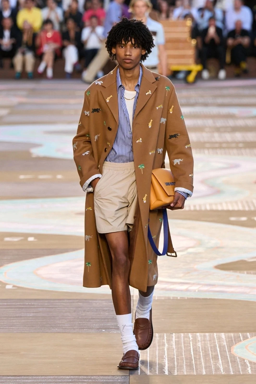 Model wearing a coffee brown coat and shorts on the Louis Vuitton runway