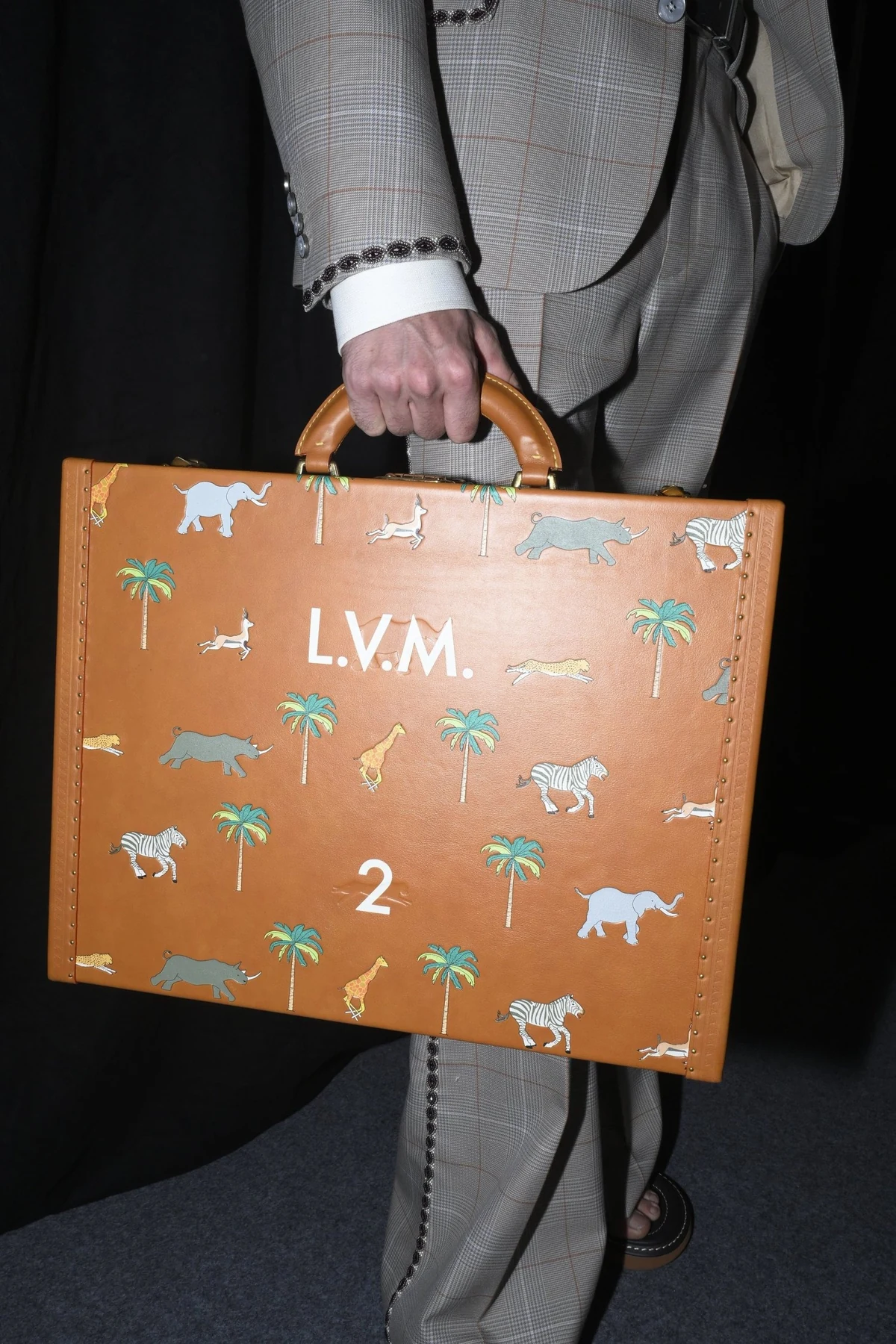 Close-up of an orange Louis Vuitton case embroidered with animal motifs