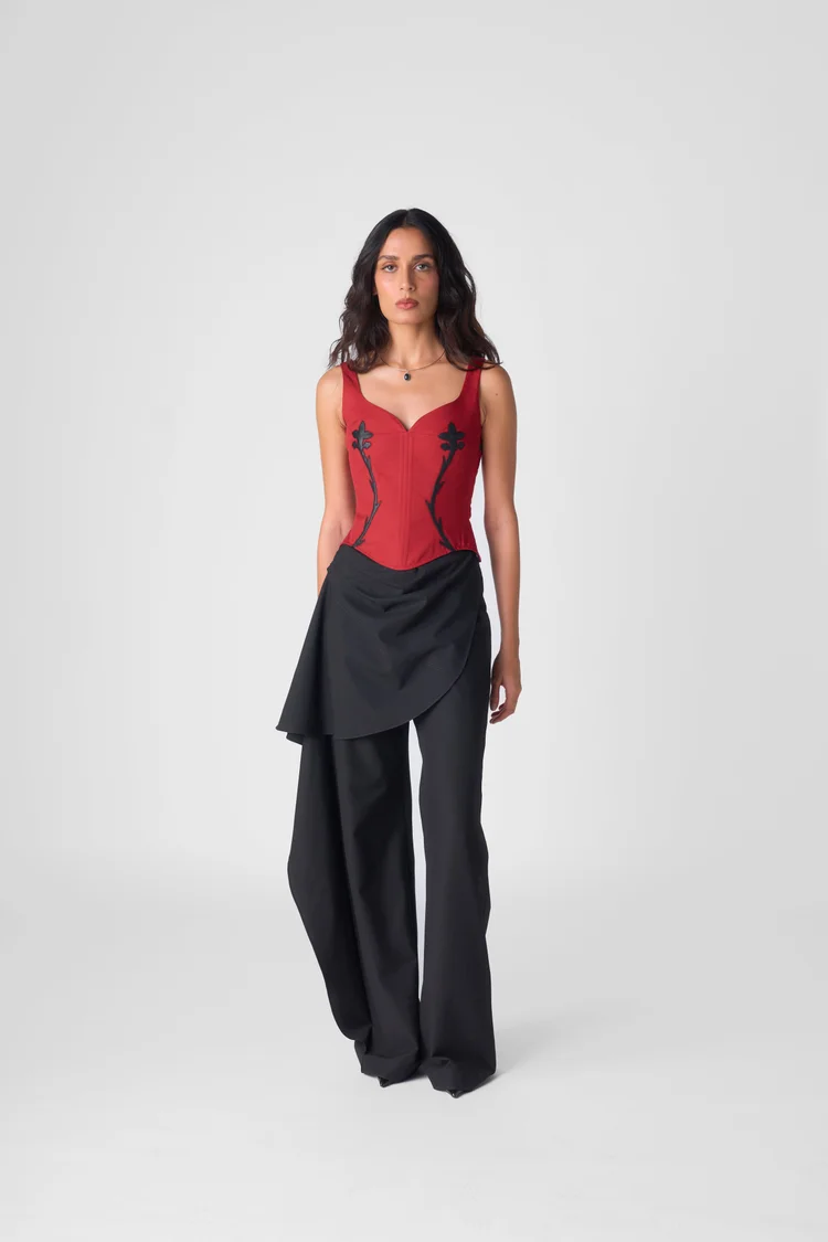 Model in a red corset and black layered trousers