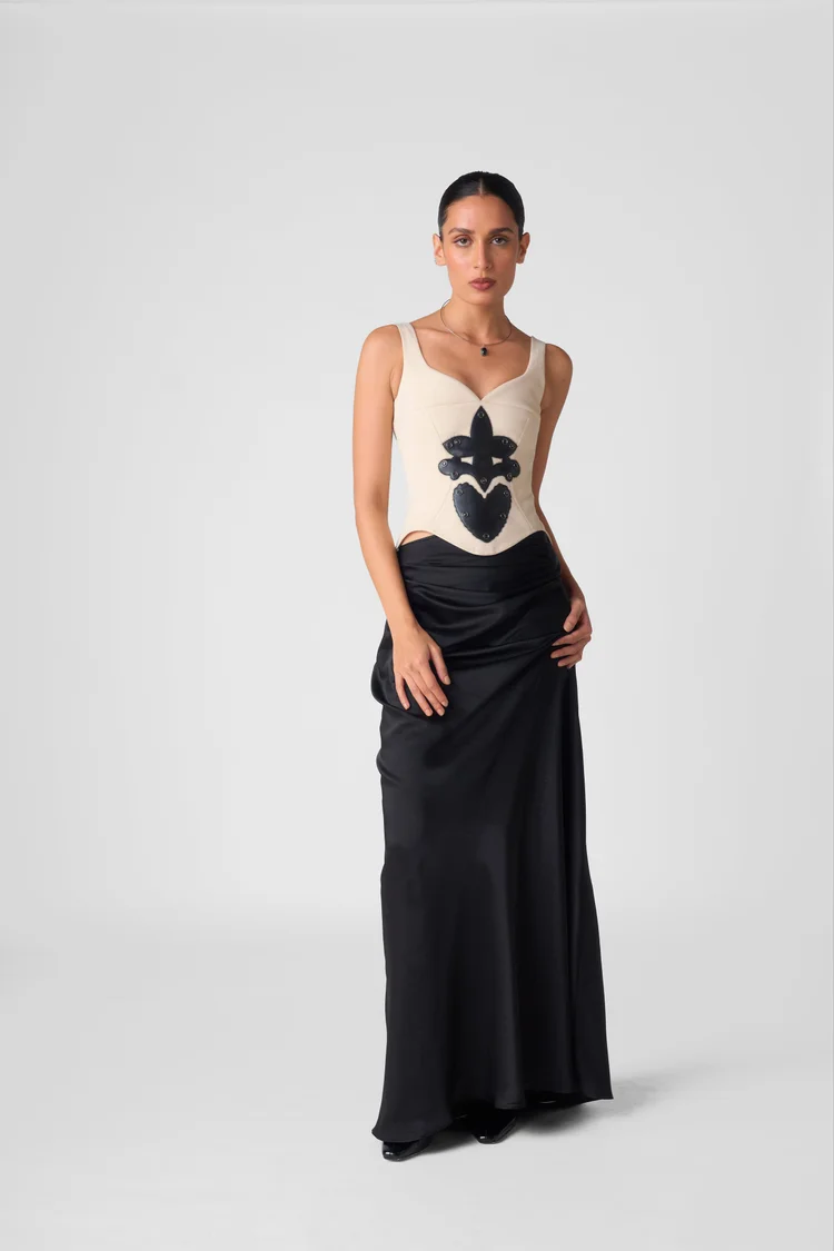 Model in a cream corset and black skirt