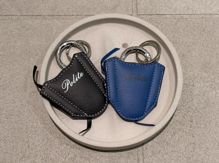 Blue and black banana leather keychains on a tray